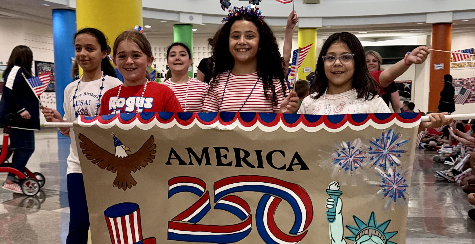 The Rogus all-school parade to celebrate the 250th anniversary of the signing of the Declaration of Independence was led by students with an America 250 banner.