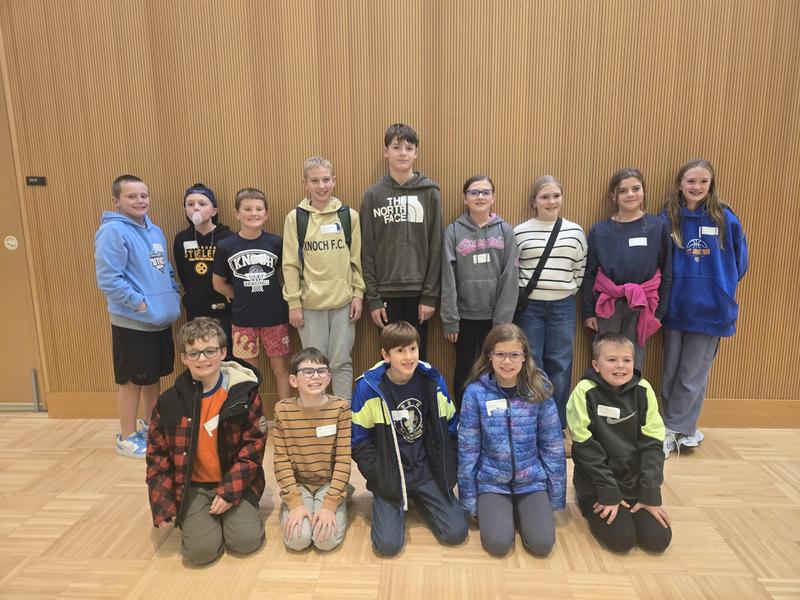 group of students gathered in front of a wall smiling