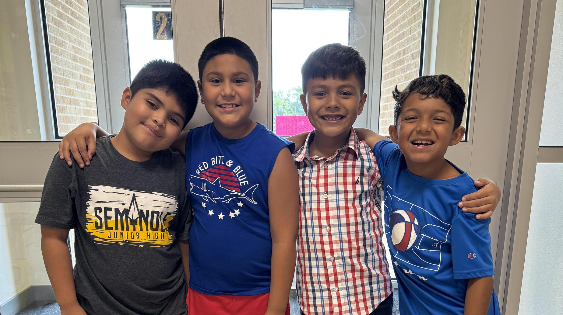 Seminole Primary students standing and smiling in the hallway.