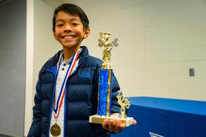 Zian Doctolero at district spelling bee with trophy