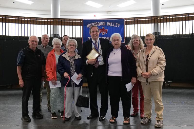 Rainville posing with his plaque and family