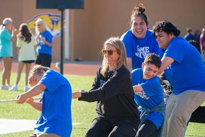 Teacher Kayci Smith plays tug-of-war with 3 special education students at field day.