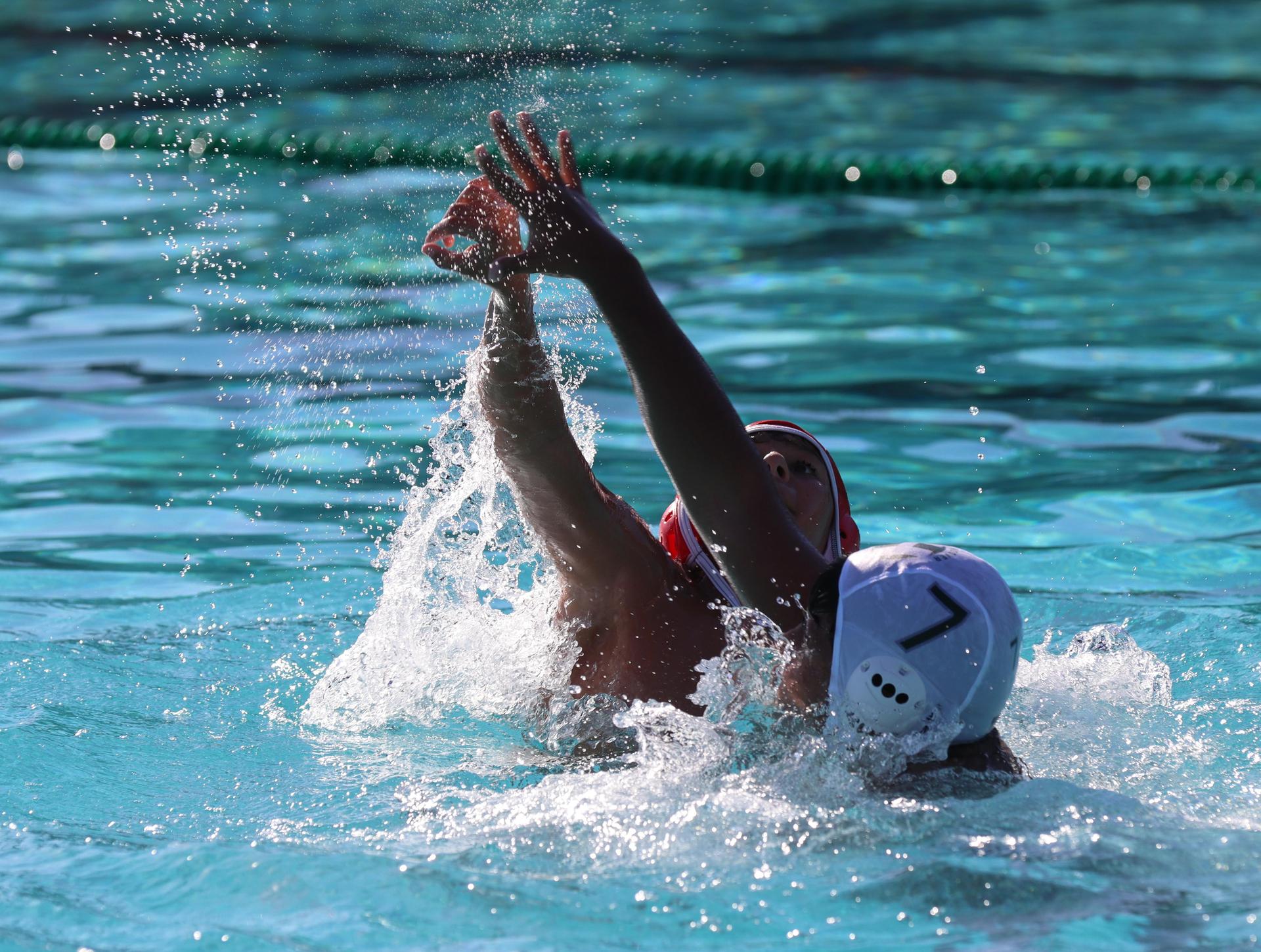 boys water polo players in action against hoover