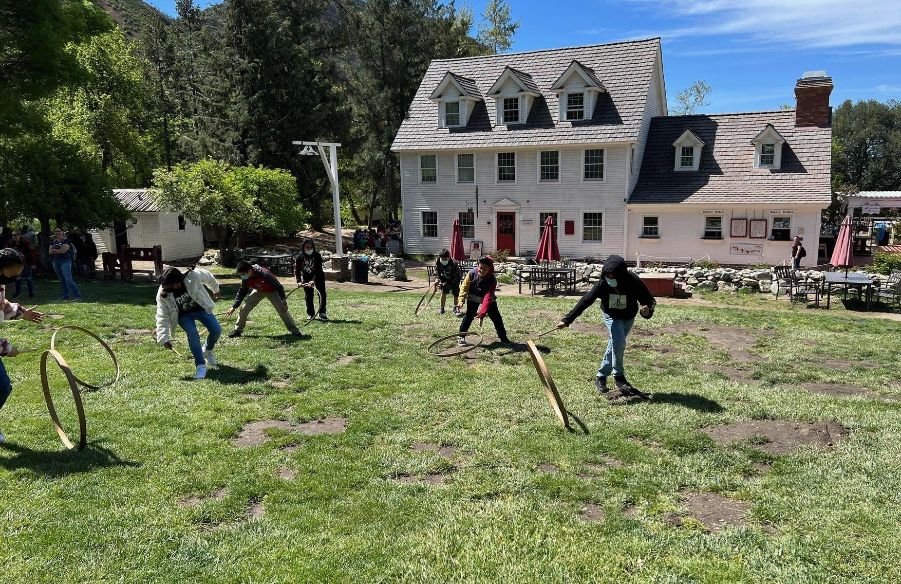 Students playing with wheels and sticks