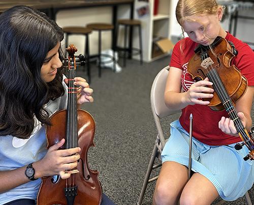 James River Day School orchestra students practicing with their violins