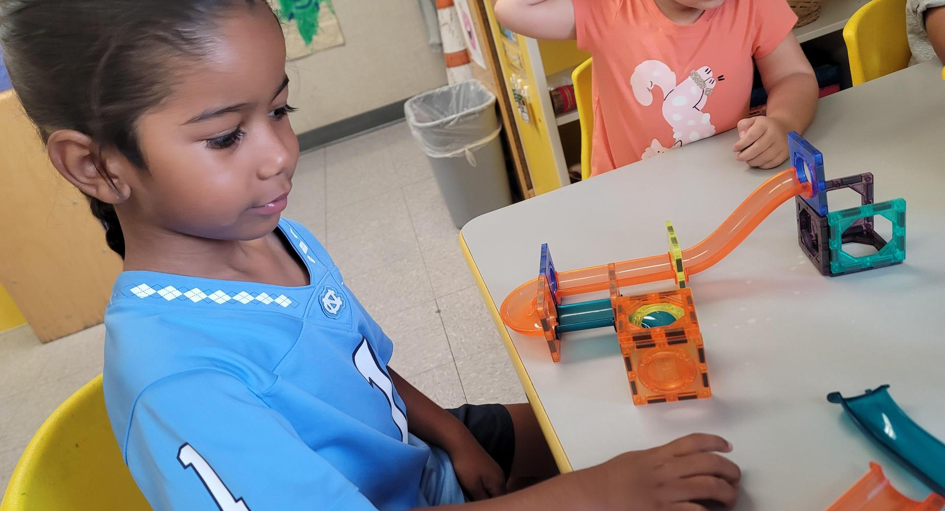 A child exploring with magnet ramps