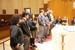 Extraordinary Ministers stand before the altar.