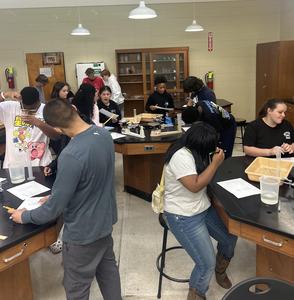 Multiple students working around lab tables in science class