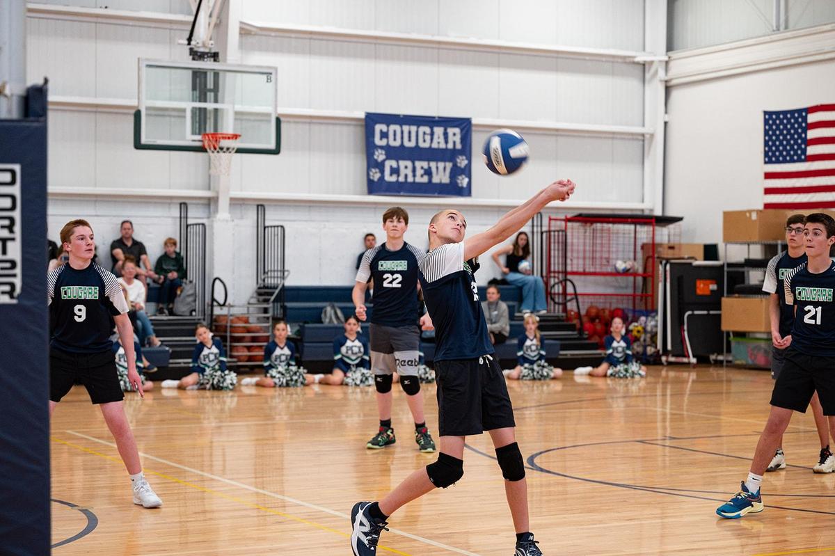 Boys Volleyball Player Bumps Towards the Net Against C2E