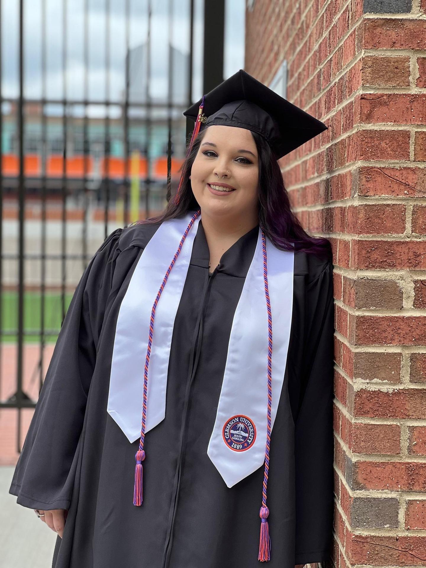 Art teacher, Erin Norris, in black graduation robe.
