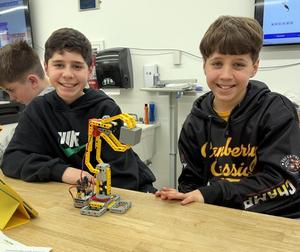 two boys with a lego robotic arm