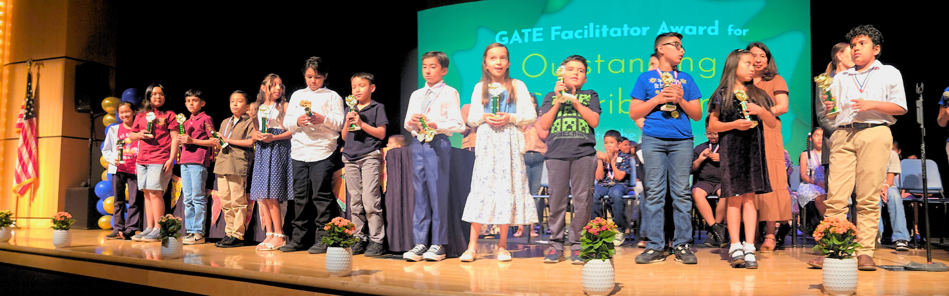 A group of students receiving awards on stage during a ceremony.