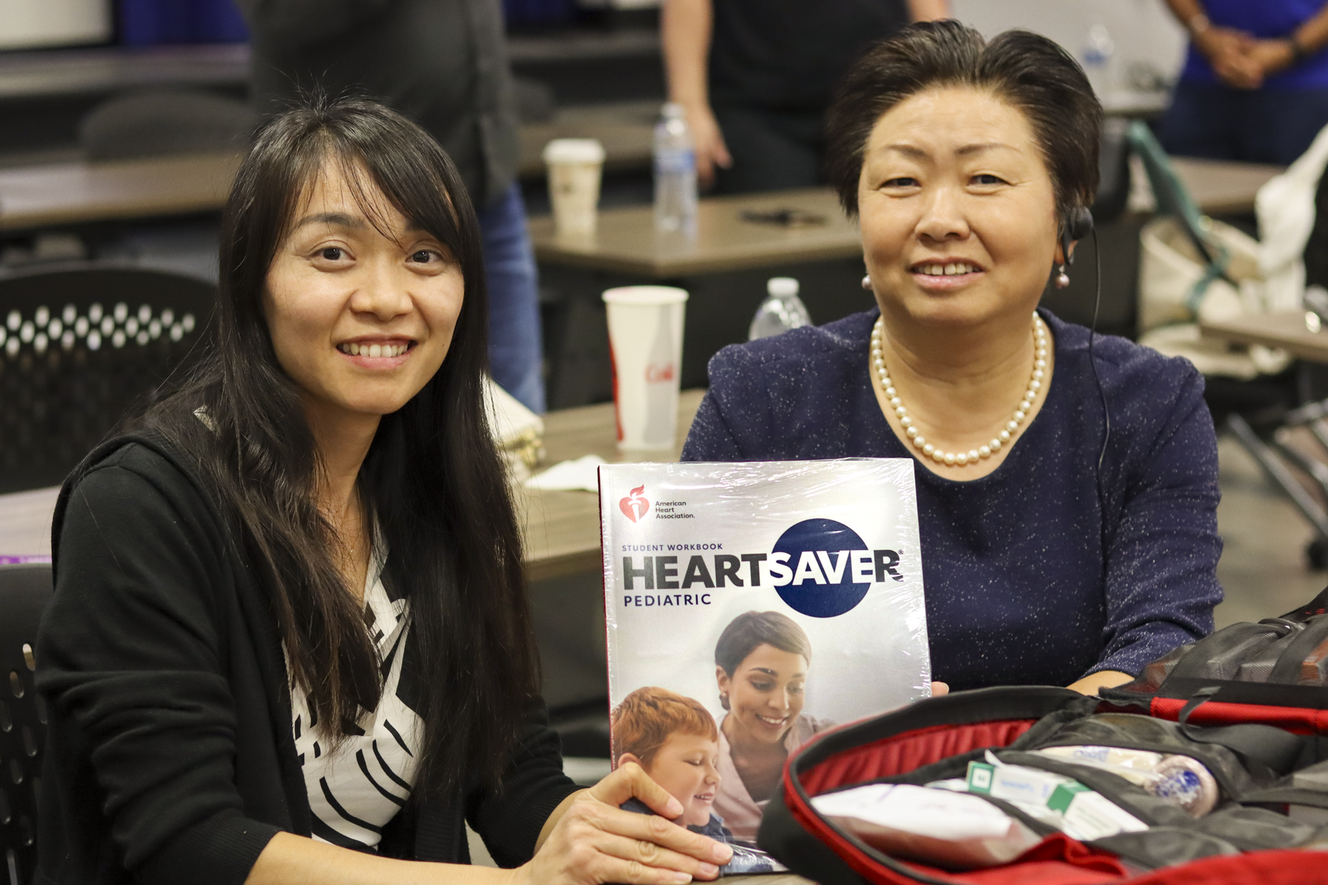 two women holding a training book