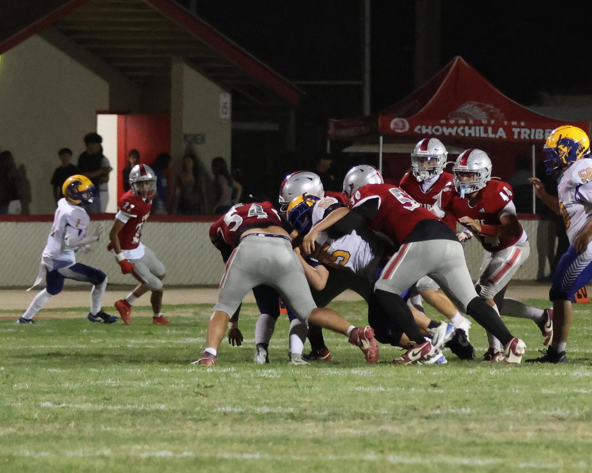 Varsity football players in action against Parlier 18