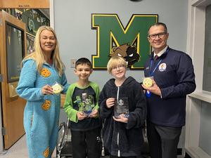 two middle school students standing between two adults