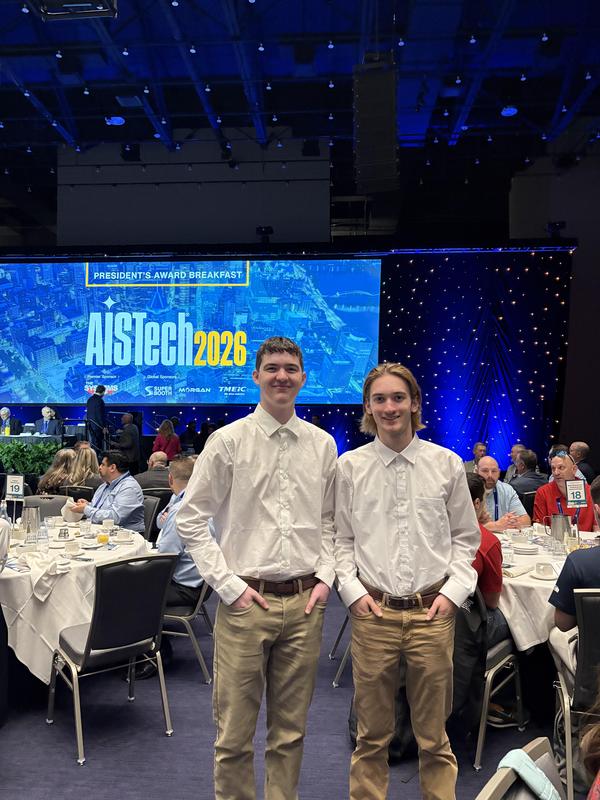 two male students dressed up in front of breakfast sign