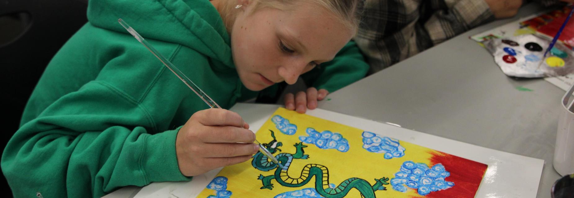 Student painting a dragon