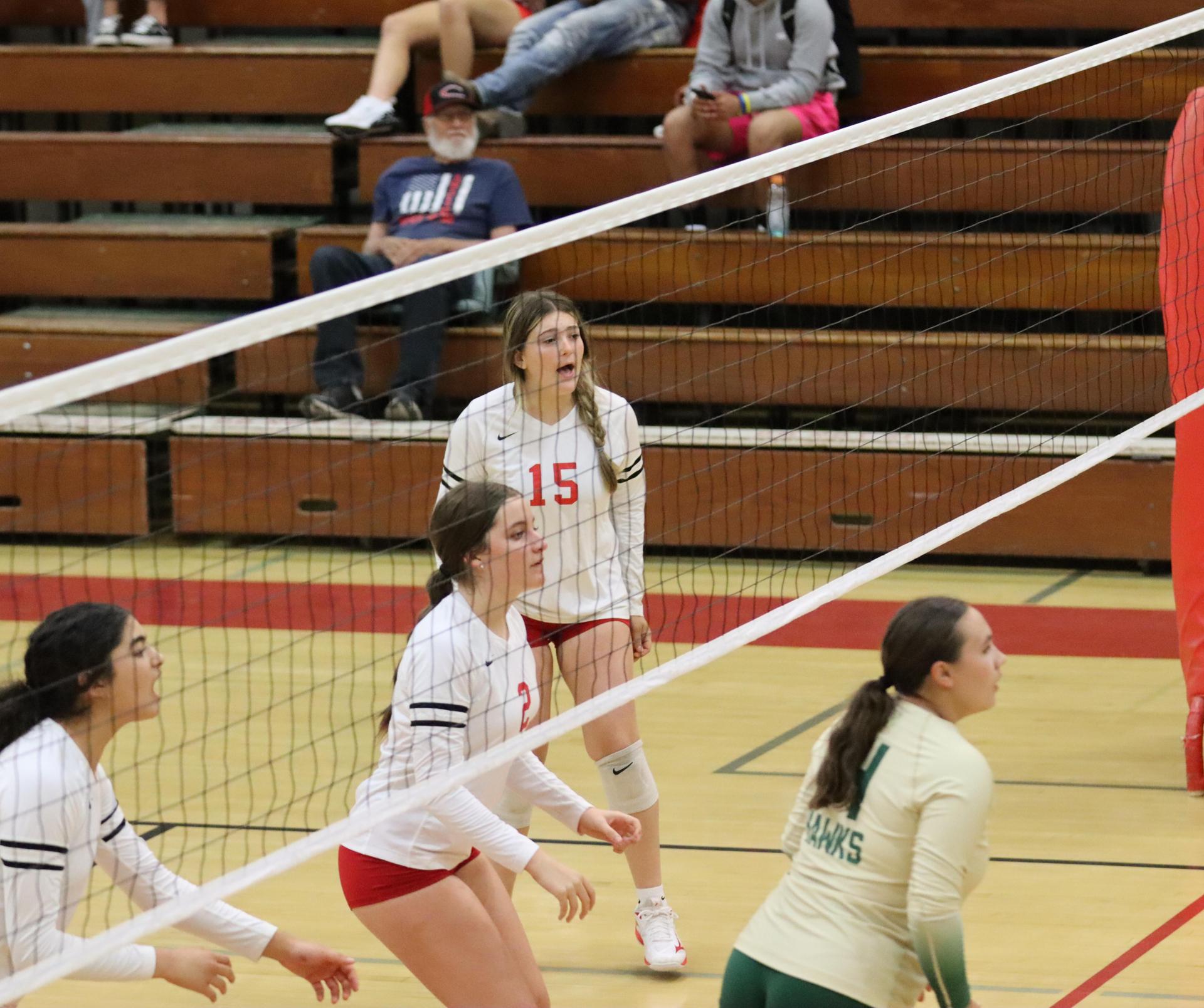 varsity volleyball players in action against liberty