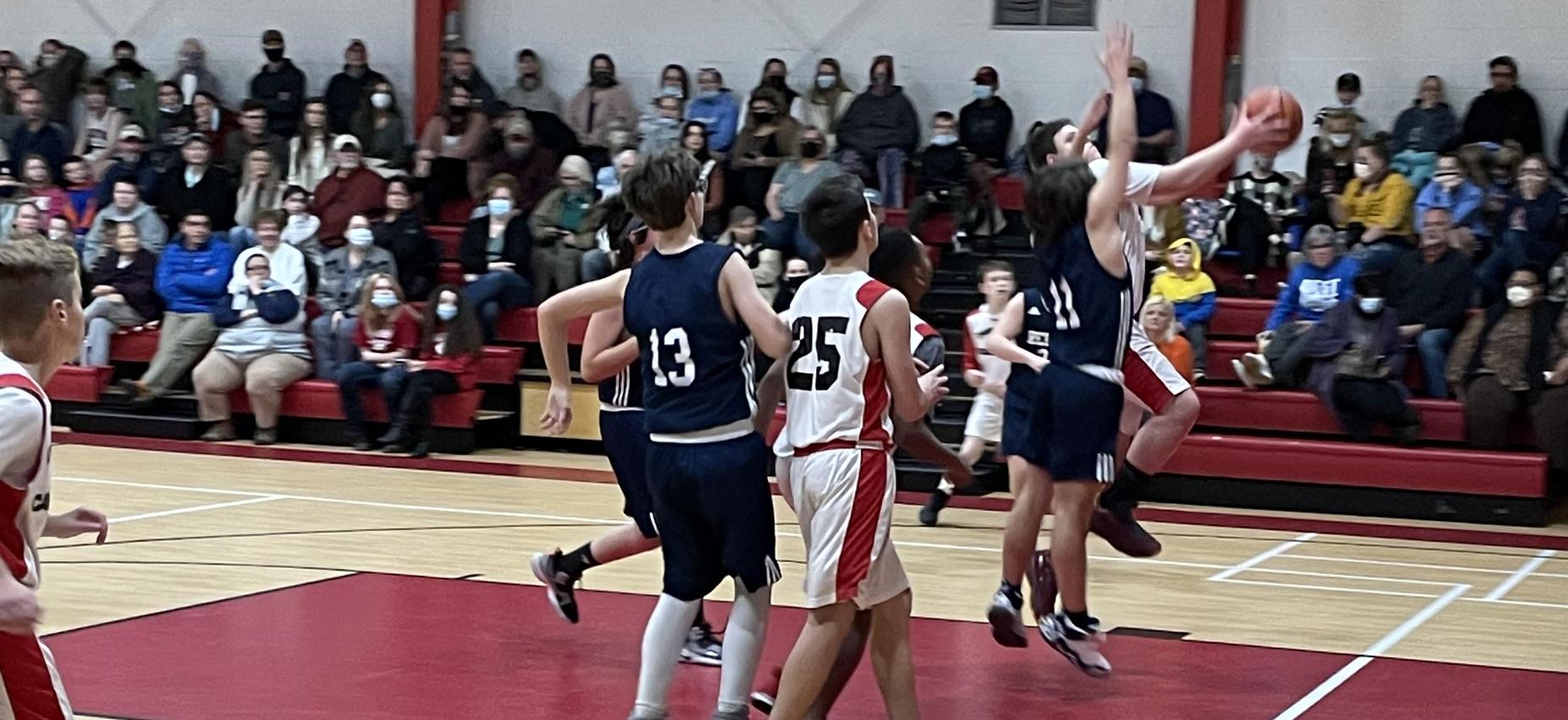 Basketball players play in a gym.