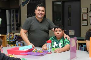 dad and son pose for a photo at family STEAM night