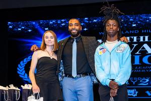 Brown with two student athletes at annual awards ceremony