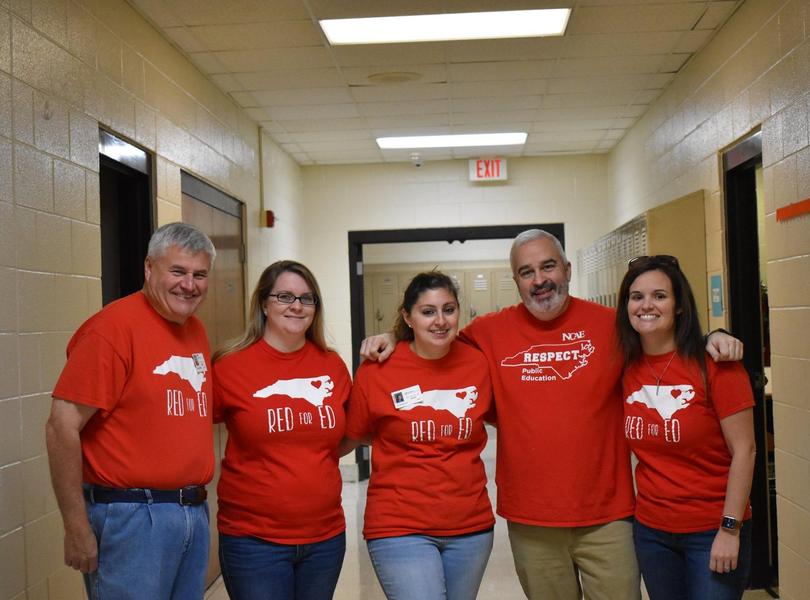 8th grade teachers plus art teacher posing in hallway
