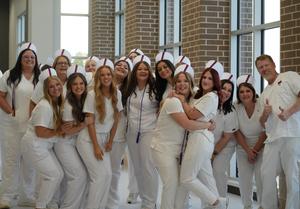 group of practical nursing students in white scrubs