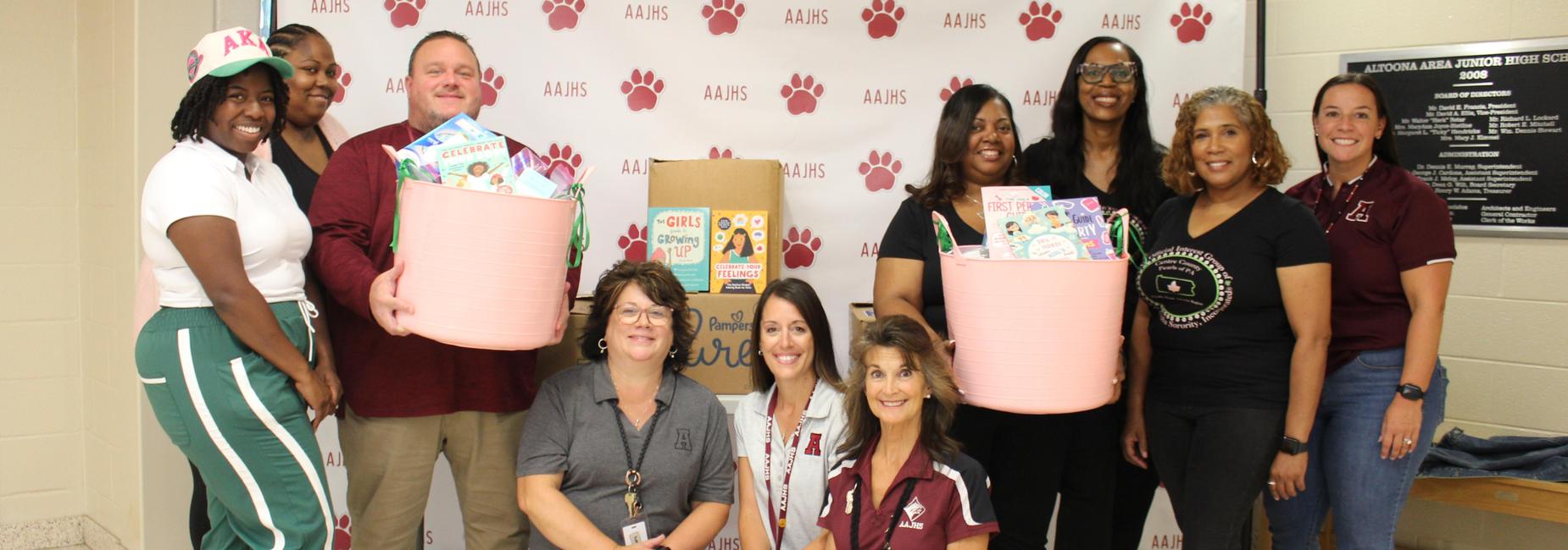 A group of people smiling and holding donation items for a charitable event.