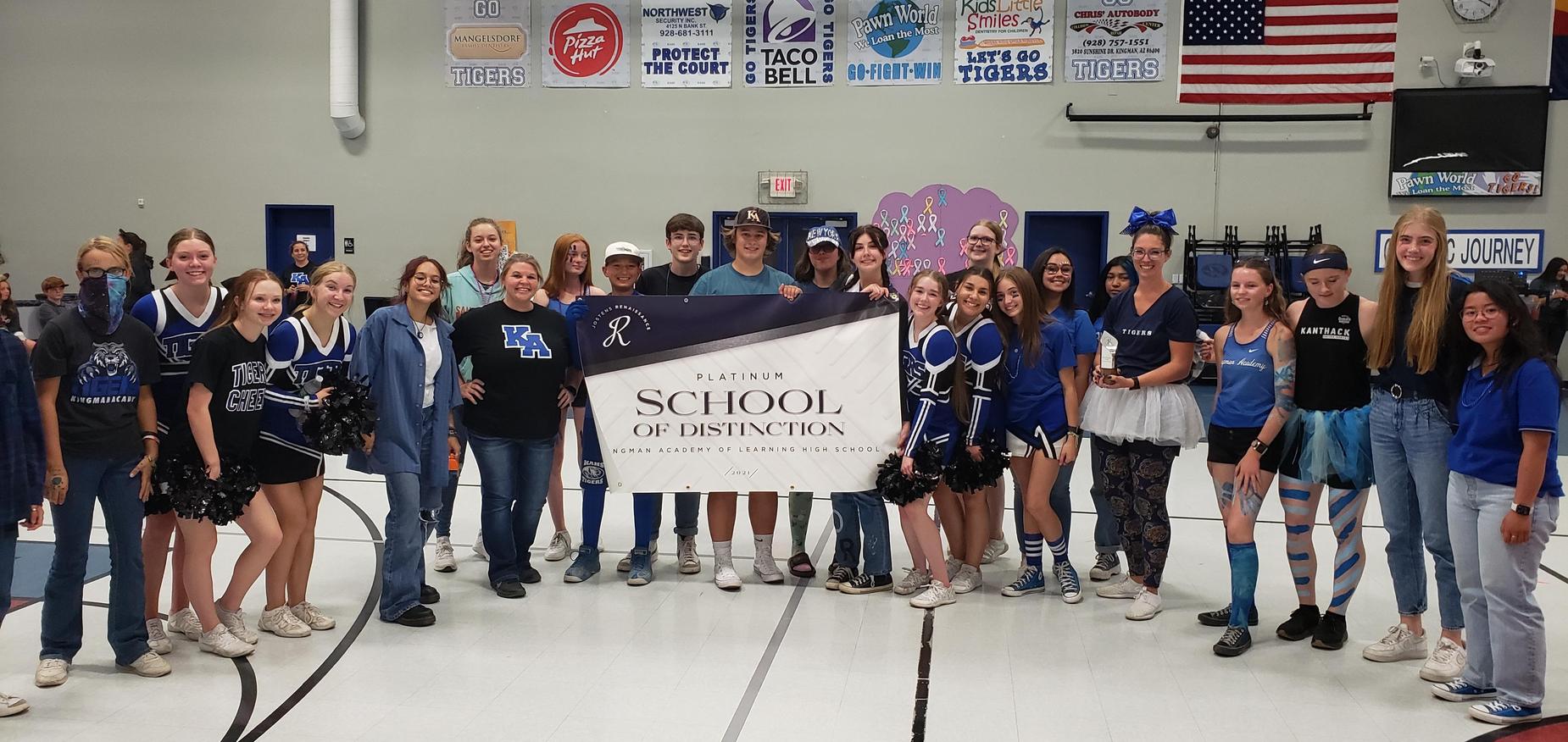 students hold Platinum School of Distinction sign