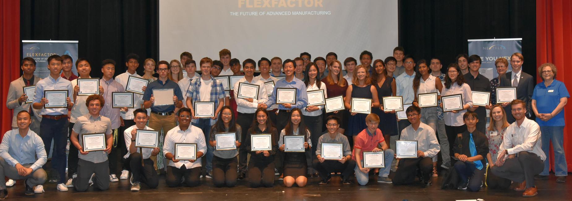 Enginerring students gathering on a stage with certificates.