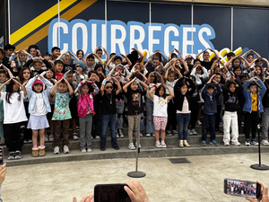 A large group of children and adults posing together in an outdoor setting.