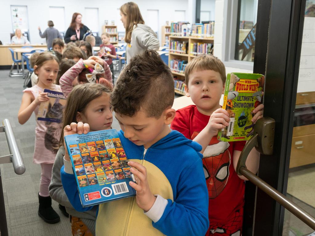 Students showing books to the photographer.