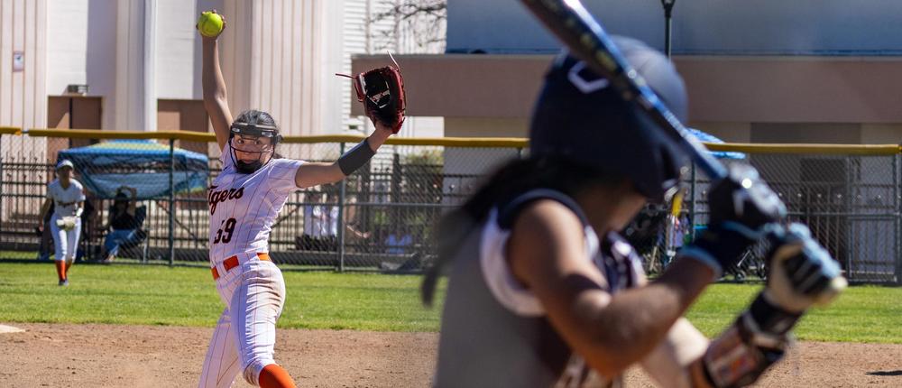girl pitching on softball field