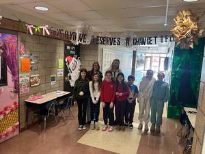 a group of students and teachers in a school hallway