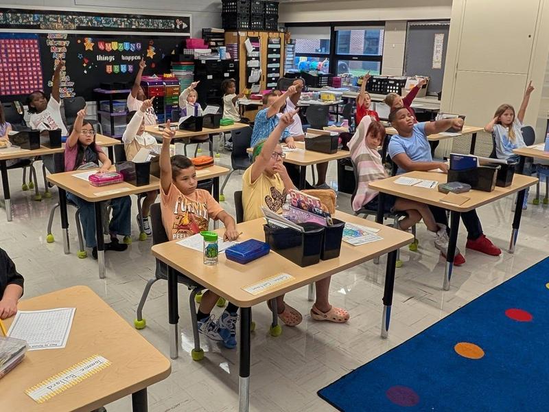 students raise their hands at FSES