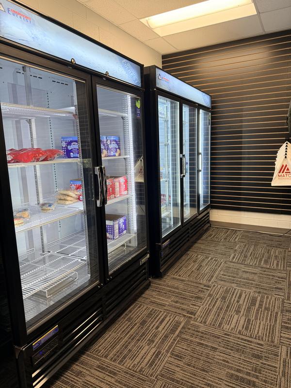 Refrigerators displaying various products in a store environment.