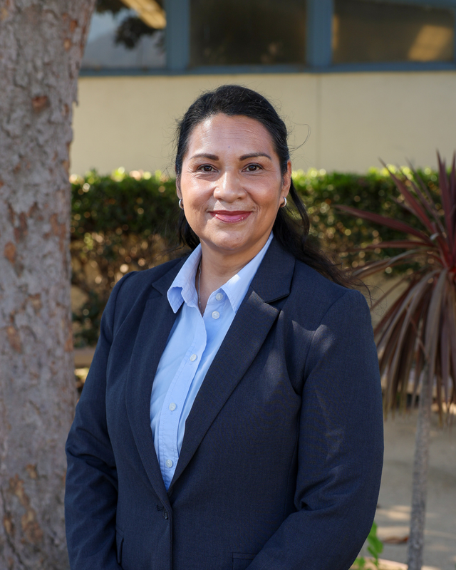 Principal Bañuelos smiling and posing outside at the Beardslee campus