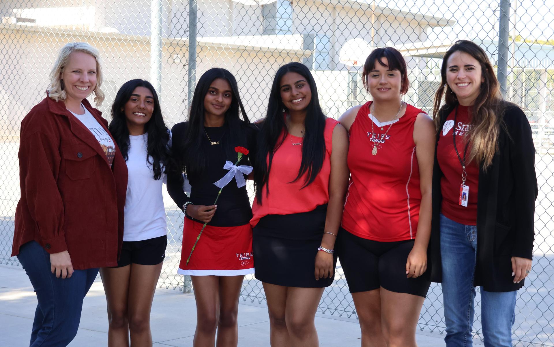 tennis players, family, and staff celebrating senior night