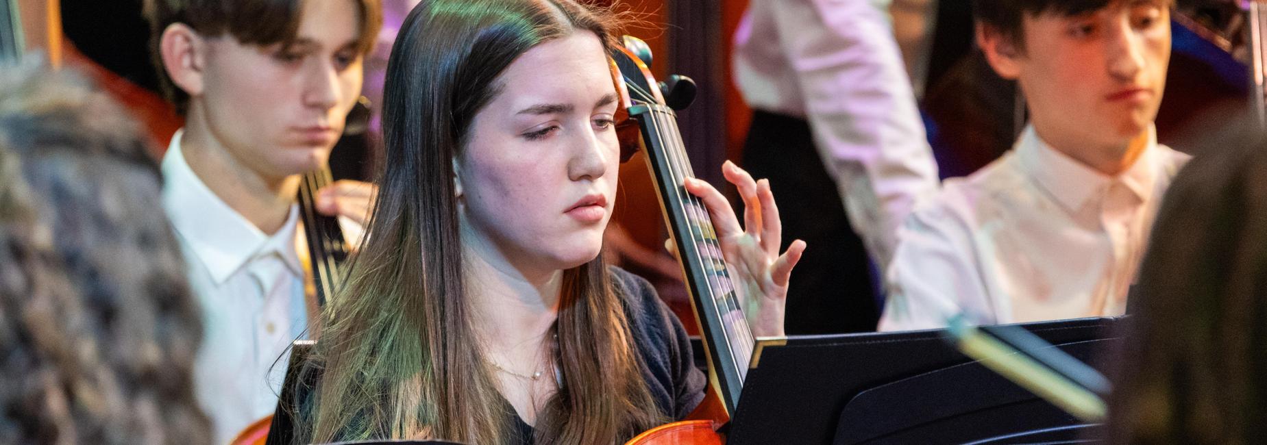 A cellist plays with the high school orchestra