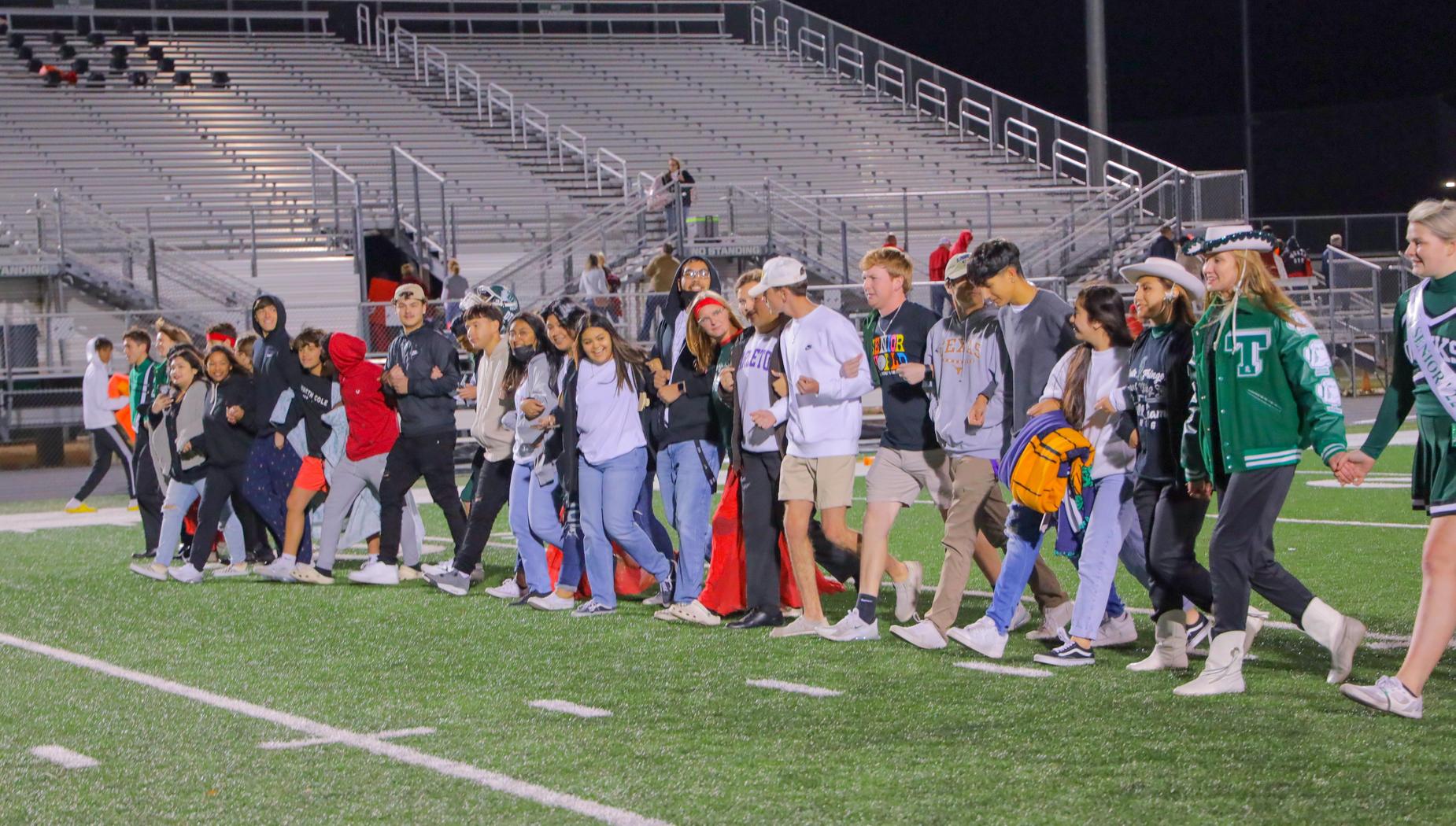Seniors crossing football field