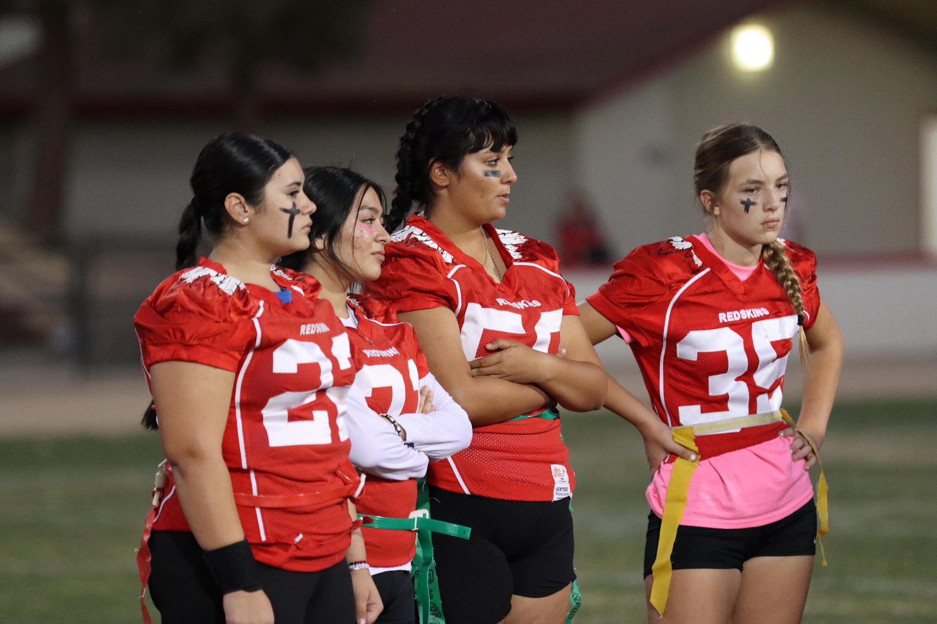 players, cheerleaders, and officials preparing for the powderpuff football game