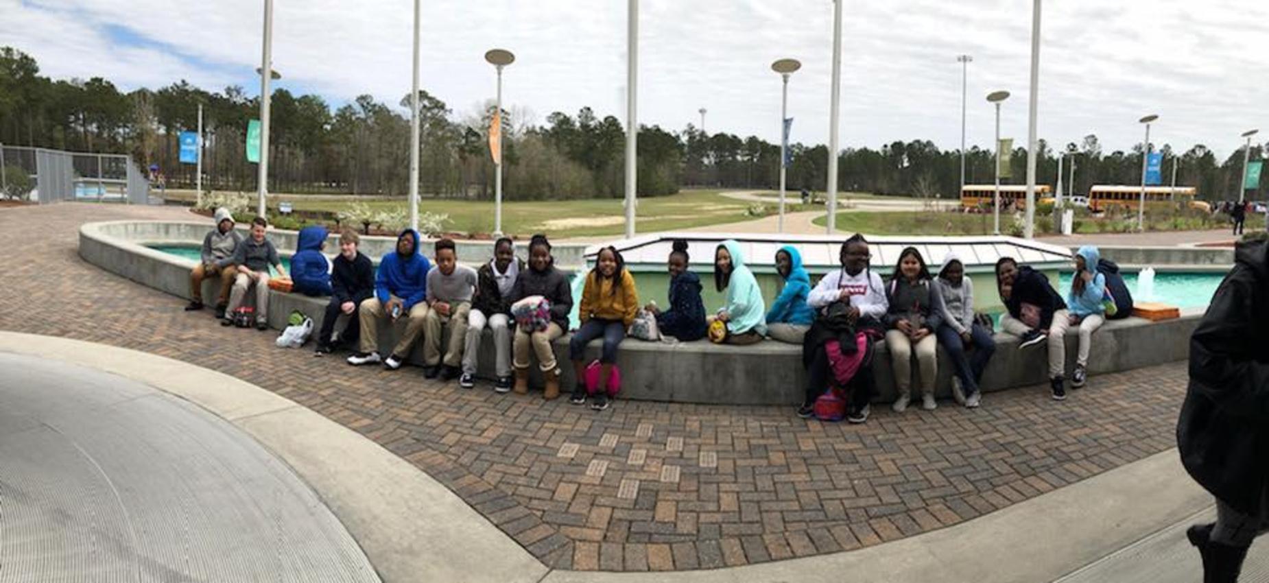 students sitting around fountain