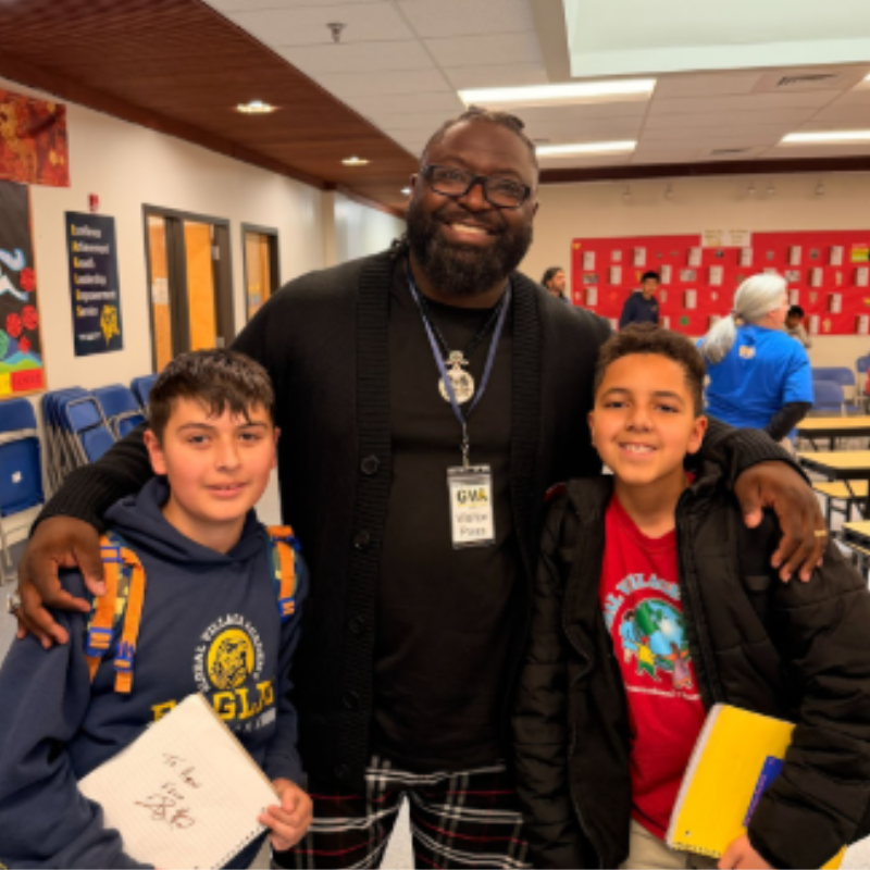 Students with guest speaker at Global Village Academy Aurora Black History Month assembly