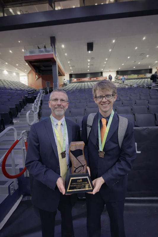 Two guys standing with a trophy for band