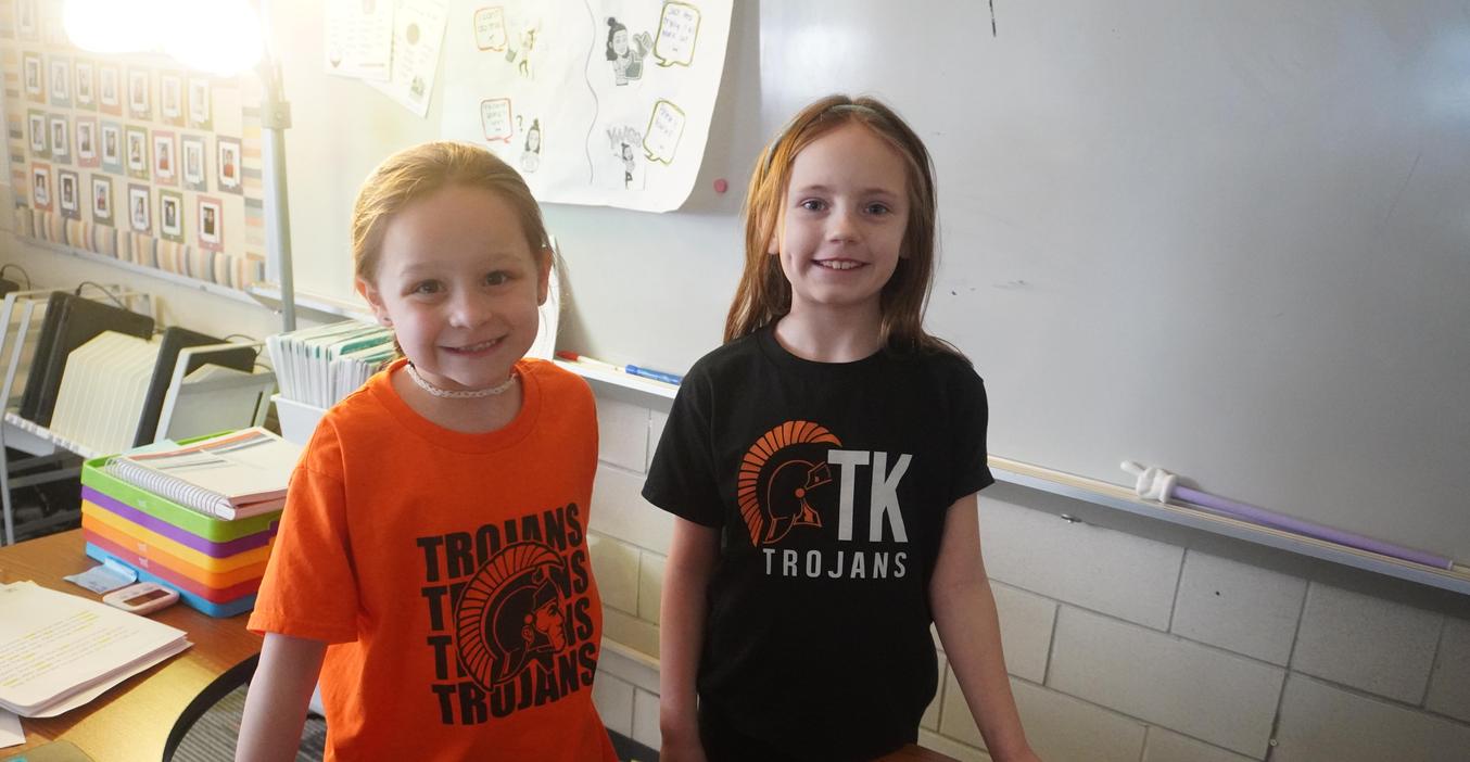 Two students wear their TK t-shirts.