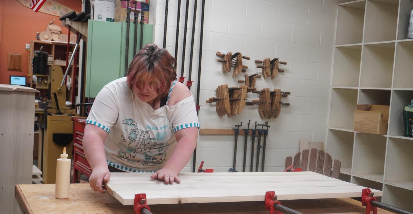 A student clamps wood pieces together in woods class.
