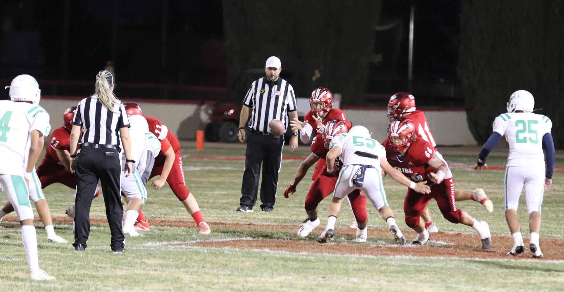 varsity football players in action against Riverdale