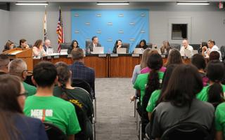 Board meeting photo showing board sitting at dais.