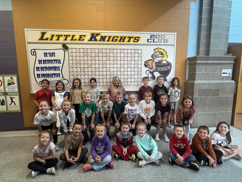 group of primary students in front of little knights board