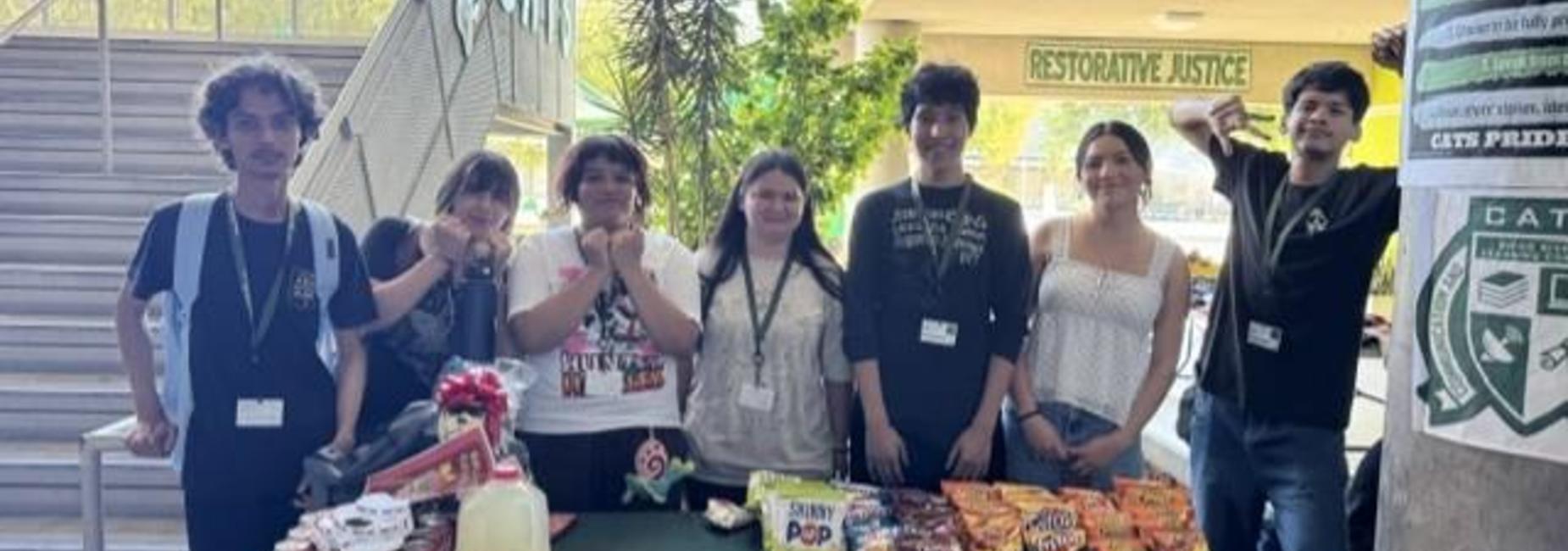 Students behind table with food and drinks